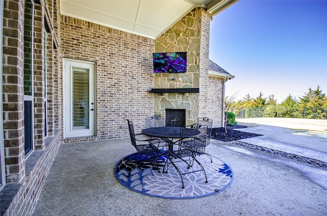 view of patio / terrace featuring an outdoor stone fireplace and outdoor dining space