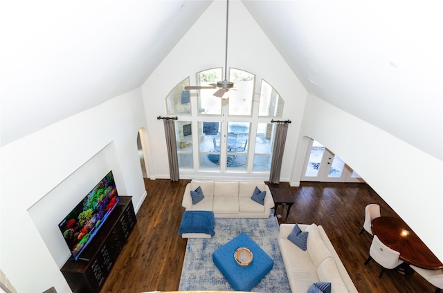 living area featuring high vaulted ceiling, arched walkways, ceiling fan, and wood finished floors