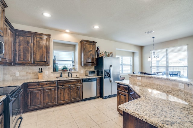 kitchen with visible vents, backsplash, appliances with stainless steel finishes, dark brown cabinetry, and a sink