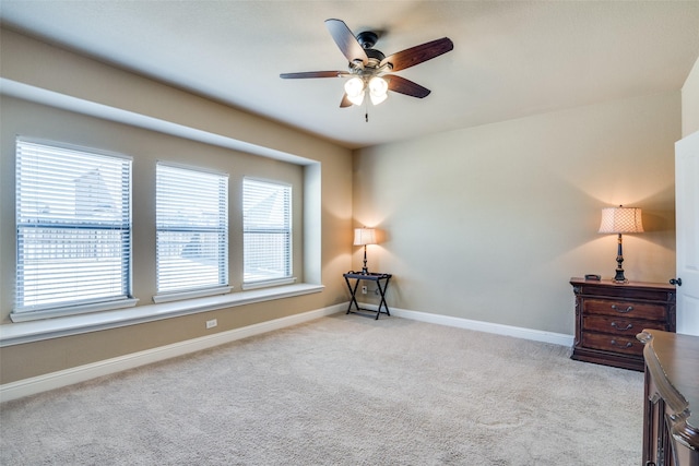 living area with carpet, a ceiling fan, and baseboards