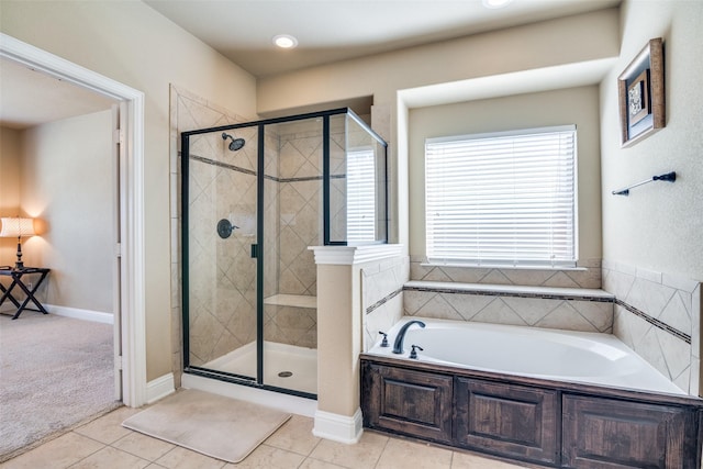 bathroom with tile patterned flooring, a shower stall, a bath, and baseboards