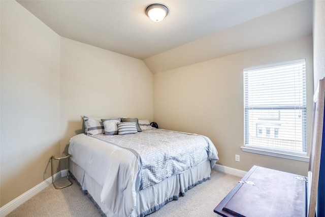 bedroom with light carpet, vaulted ceiling, and baseboards