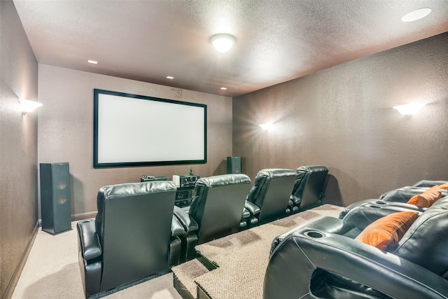 carpeted home theater room with a textured wall, a textured ceiling, and baseboards