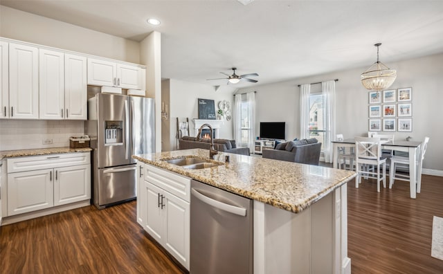 kitchen featuring stainless steel appliances, white cabinets, a sink, and dark wood-style floors