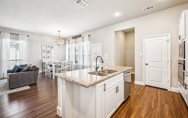 kitchen featuring stainless steel appliances, dark wood finished floors, a sink, and visible vents