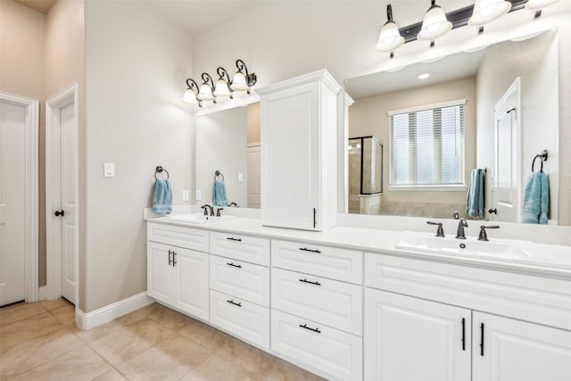 bathroom with double vanity, a shower with shower door, a sink, and tile patterned floors