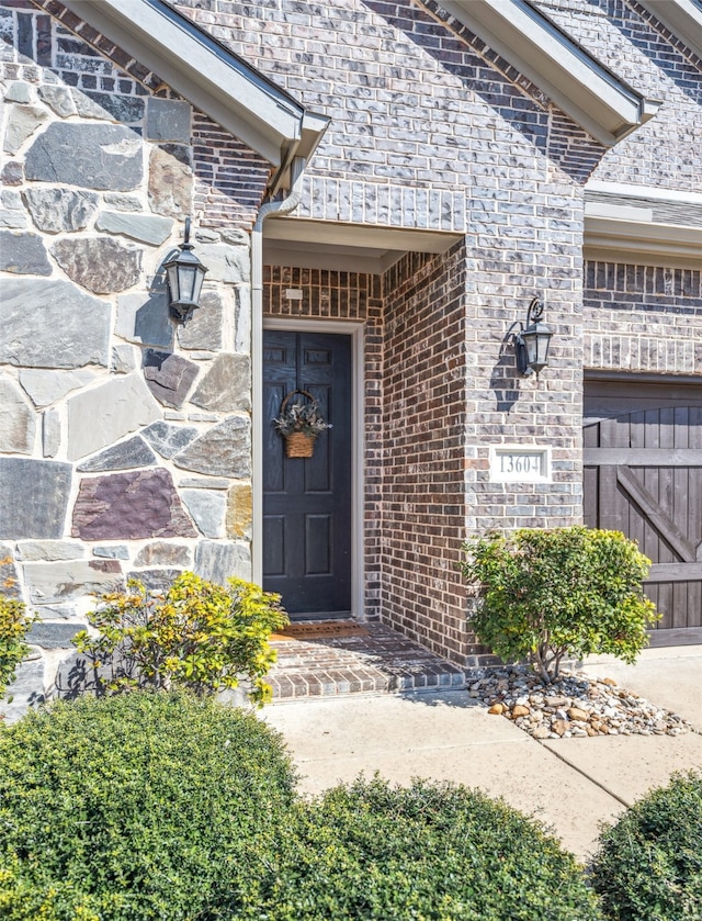 view of exterior entry featuring brick siding