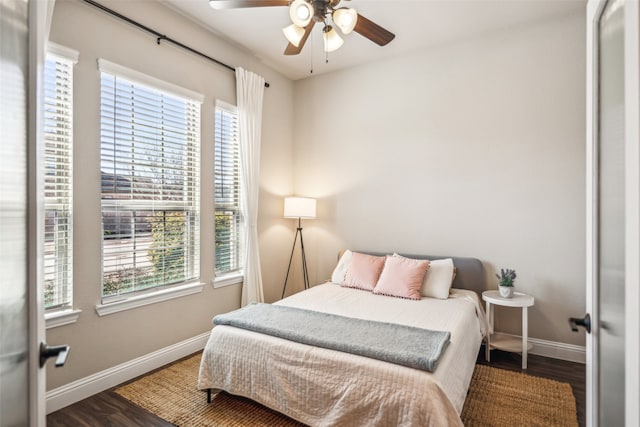 bedroom featuring a ceiling fan, baseboards, and wood finished floors