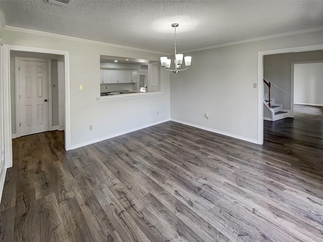 unfurnished dining area featuring ornamental molding, dark wood-type flooring, a textured ceiling, and a notable chandelier