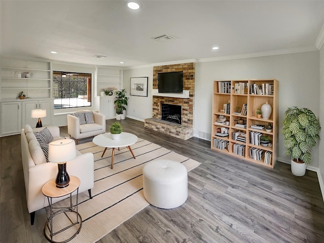 living area featuring a fireplace, ornamental molding, wood finished floors, and recessed lighting