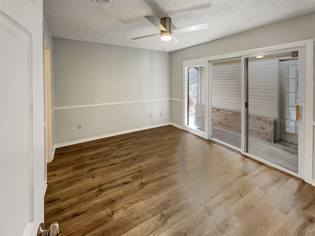 spare room with ceiling fan, a textured ceiling, baseboards, and wood finished floors