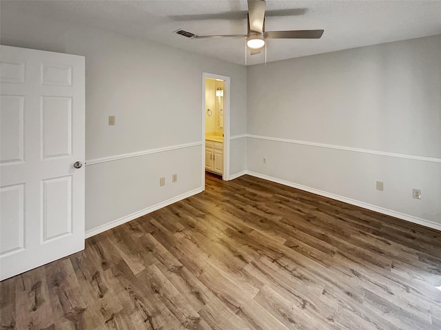 spare room featuring ceiling fan, wood finished floors, and baseboards