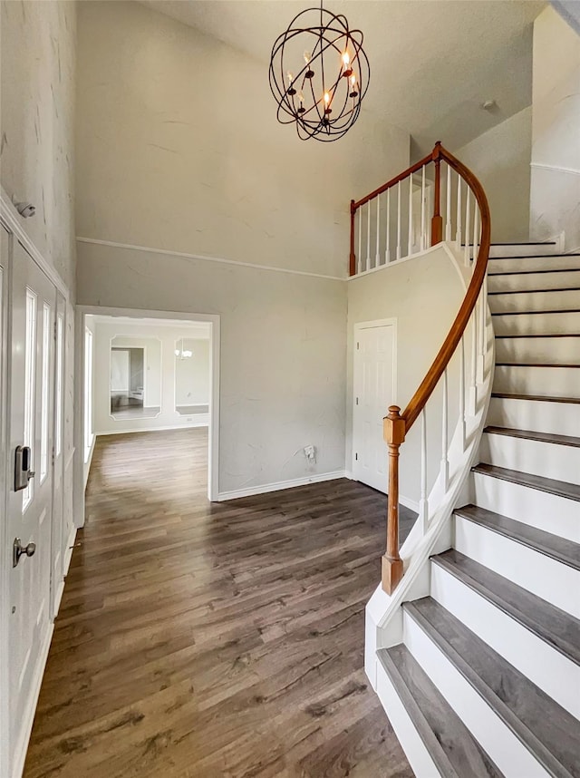 entryway featuring a chandelier, stairway, a high ceiling, and wood finished floors