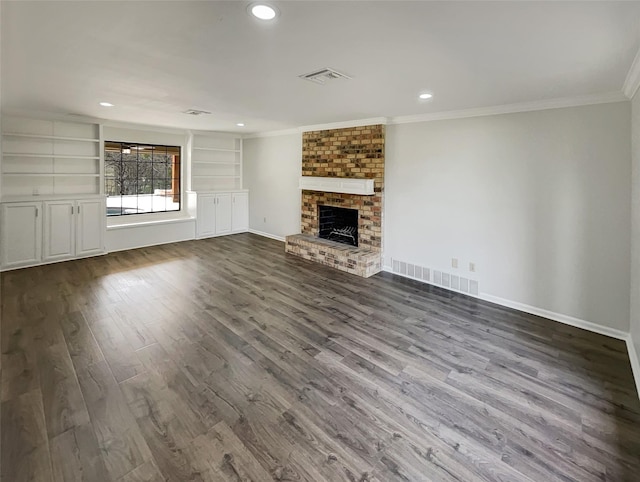 unfurnished living room featuring visible vents, baseboards, dark wood-style flooring, crown molding, and a brick fireplace