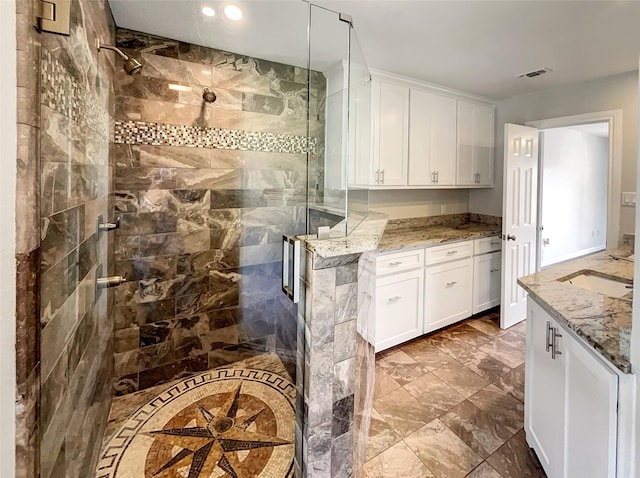 kitchen featuring recessed lighting, visible vents, white cabinetry, a sink, and light stone countertops