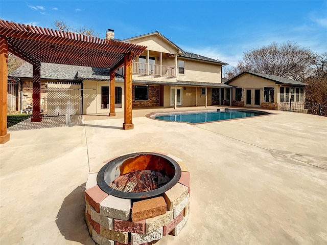 view of pool featuring a patio, an outdoor fire pit, fence, french doors, and a pergola