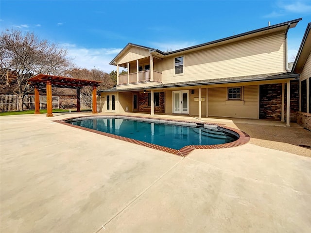 pool with fence, a pergola, french doors, and a patio