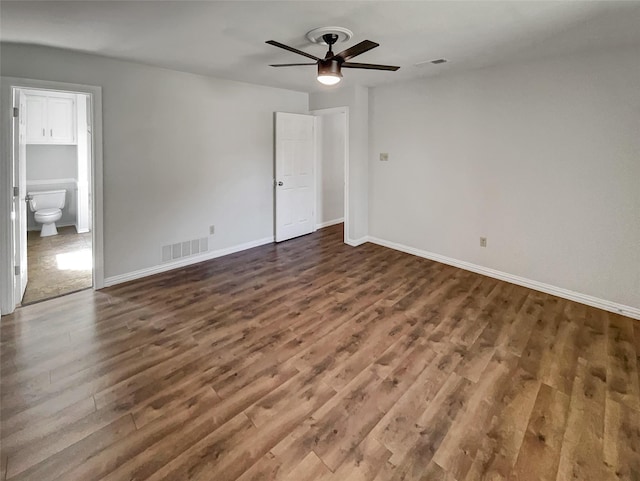 unfurnished bedroom with baseboards, connected bathroom, visible vents, and wood finished floors