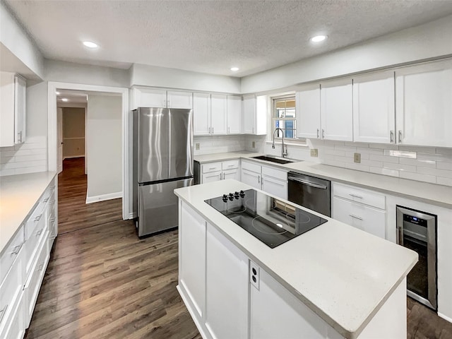 kitchen featuring beverage cooler, white cabinets, dark wood-type flooring, stainless steel appliances, and a sink