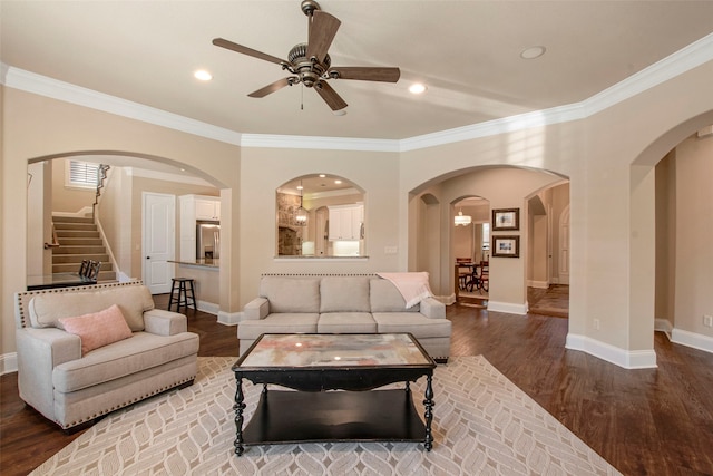 living area with crown molding, baseboards, and wood finished floors