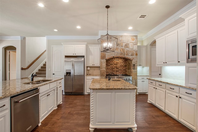 kitchen with visible vents, crown molding, custom range hood, appliances with stainless steel finishes, and a sink