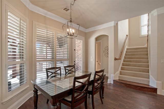 dining space with visible vents, a notable chandelier, dark wood-style floors, crown molding, and stairs