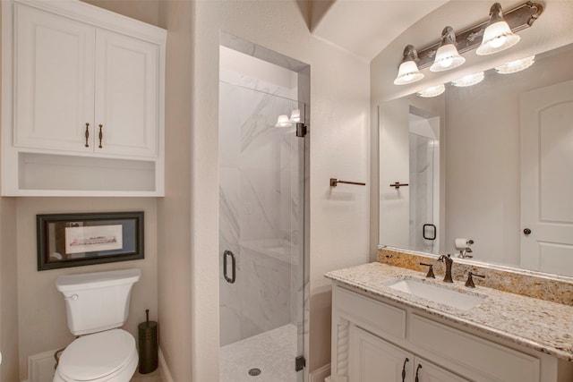 bathroom with a marble finish shower, toilet, and vanity