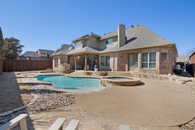 view of pool featuring a patio, a fenced backyard, and a pool with connected hot tub