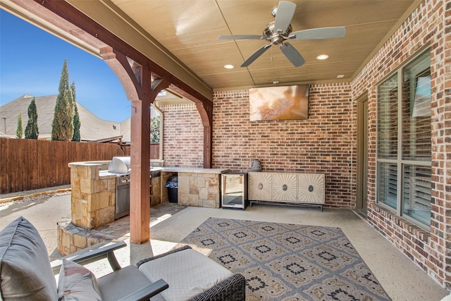 view of patio / terrace featuring an outdoor kitchen, a grill, ceiling fan, and fence