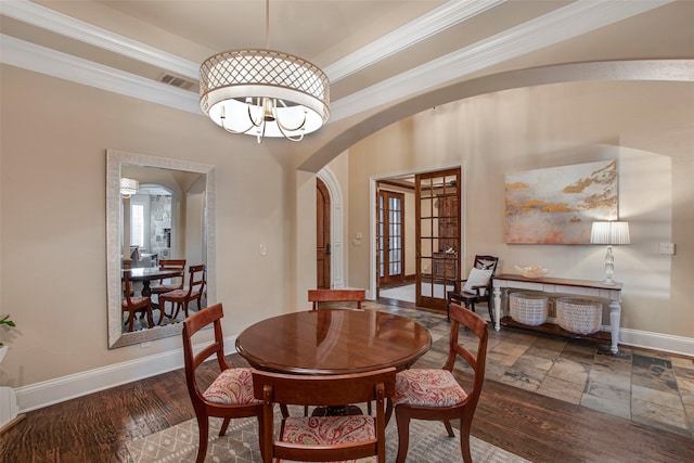 dining room featuring visible vents, a notable chandelier, ornamental molding, arched walkways, and baseboards