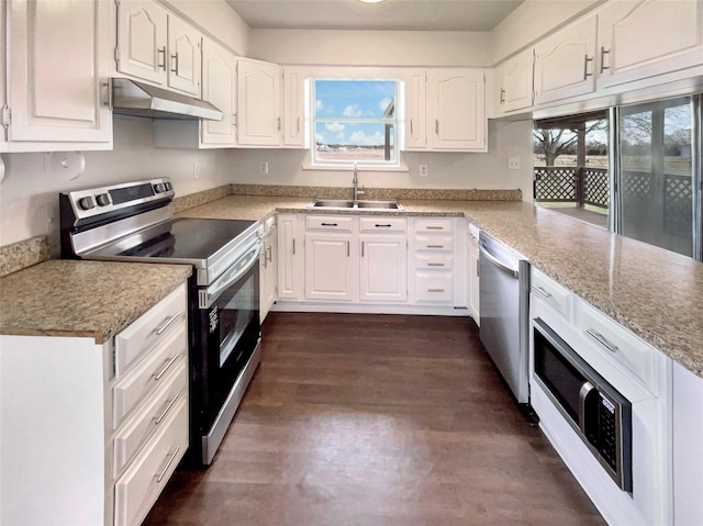 kitchen featuring appliances with stainless steel finishes, white cabinetry, a sink, and under cabinet range hood