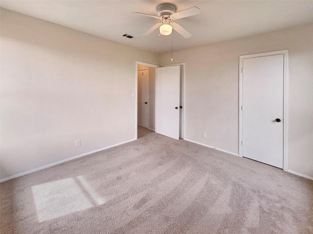 unfurnished bedroom featuring ceiling fan, carpet, visible vents, and baseboards