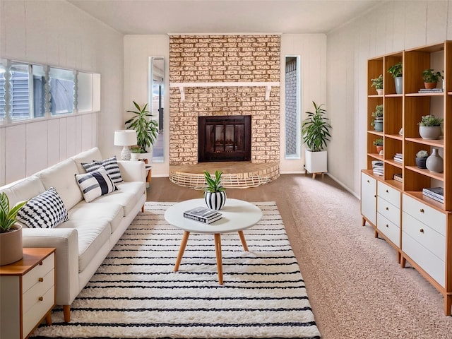 carpeted living area with a brick fireplace and wood walls