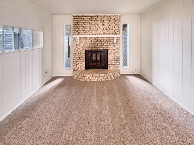 unfurnished living room with a brick fireplace, carpet flooring, and baseboards