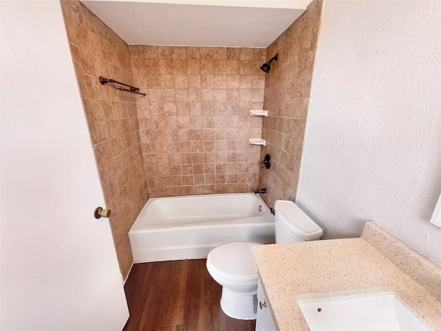 full bath featuring toilet, bathtub / shower combination, wood finished floors, and vanity