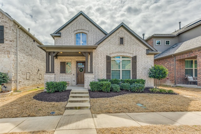 french country inspired facade with covered porch and brick siding