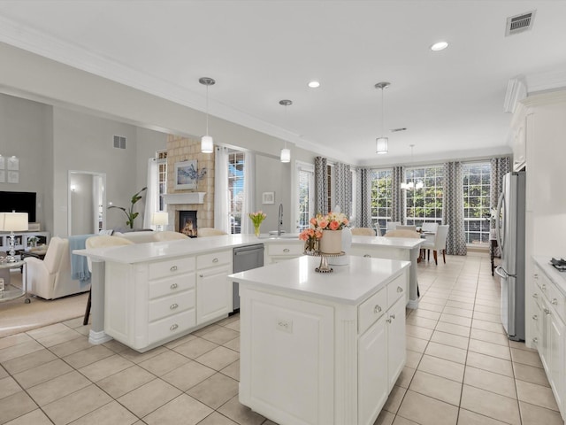 kitchen featuring visible vents, open floor plan, a center island, appliances with stainless steel finishes, and light countertops