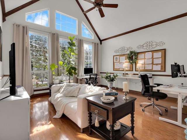 living area with a ceiling fan, crown molding, wood finished floors, and high vaulted ceiling