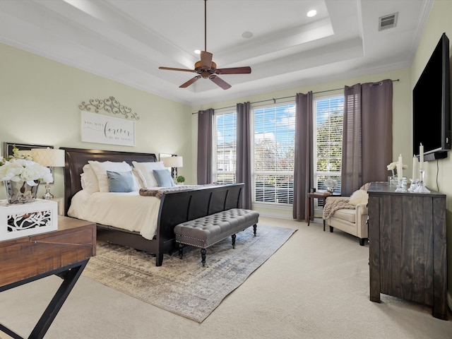 bedroom featuring a ceiling fan, visible vents, ornamental molding, light carpet, and a raised ceiling