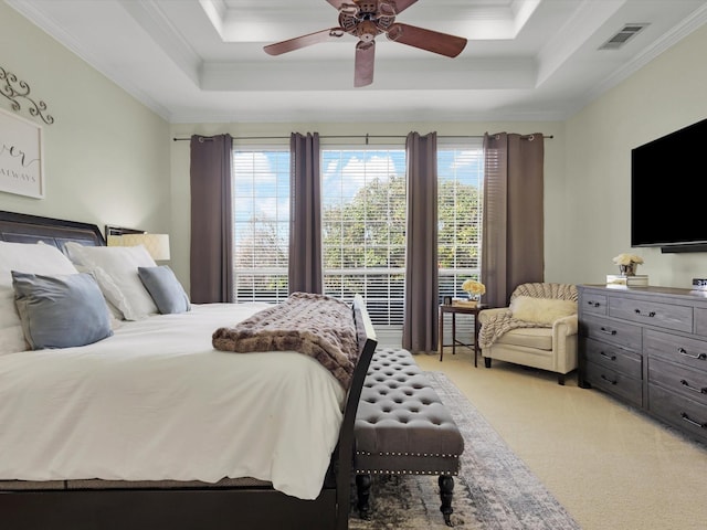 bedroom featuring light carpet, visible vents, crown molding, and a raised ceiling