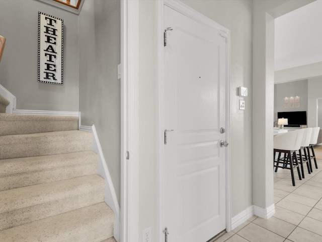 stairway featuring tile patterned flooring and baseboards