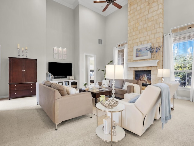 living room with visible vents, a fireplace, baseboards, light colored carpet, and ceiling fan