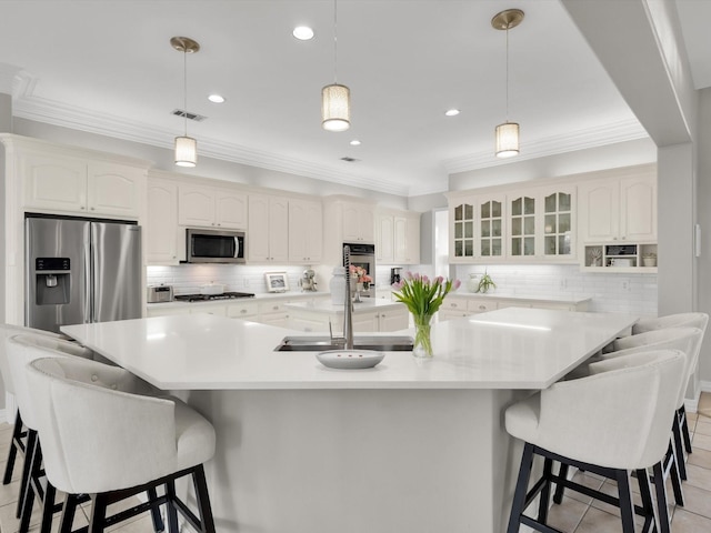 kitchen featuring a sink, stainless steel appliances, glass insert cabinets, and ornamental molding