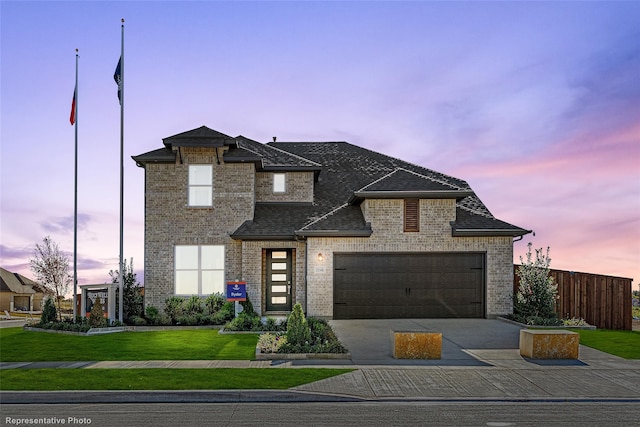 view of front of house with a garage, brick siding, a shingled roof, a yard, and concrete driveway