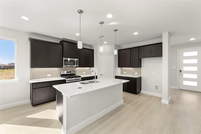 kitchen with stainless steel appliances, visible vents, a sink, and light wood finished floors