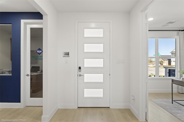 entryway featuring baseboards and wood finished floors