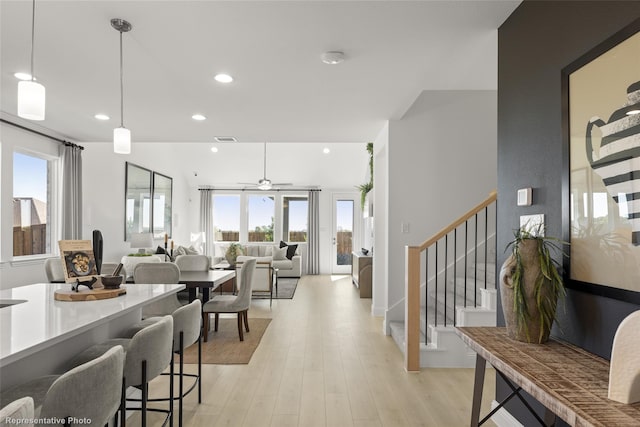 interior space featuring recessed lighting, a ceiling fan, visible vents, light wood finished floors, and decorative light fixtures