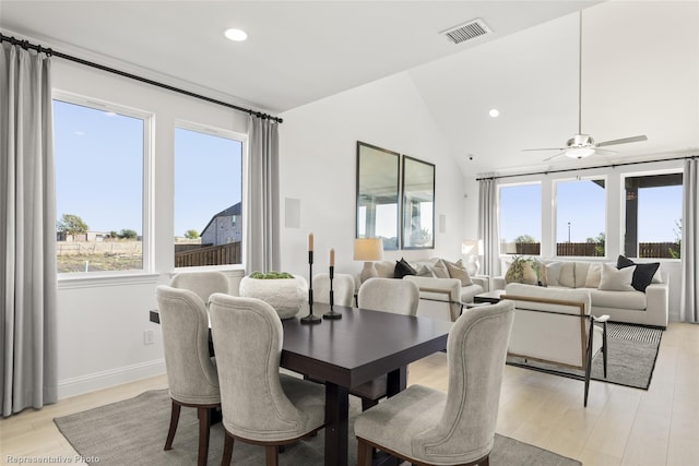 dining space featuring vaulted ceiling, light wood finished floors, visible vents, and a healthy amount of sunlight