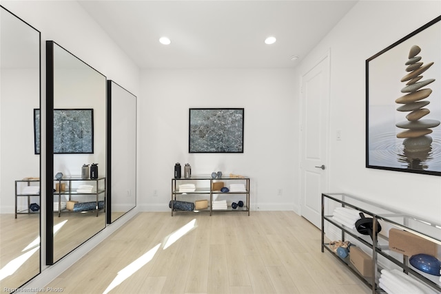 interior space with baseboards, wood finished floors, and recessed lighting