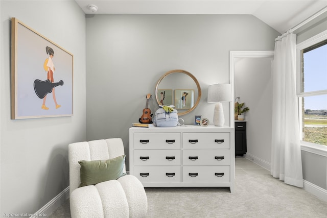 living area with vaulted ceiling, light carpet, and baseboards